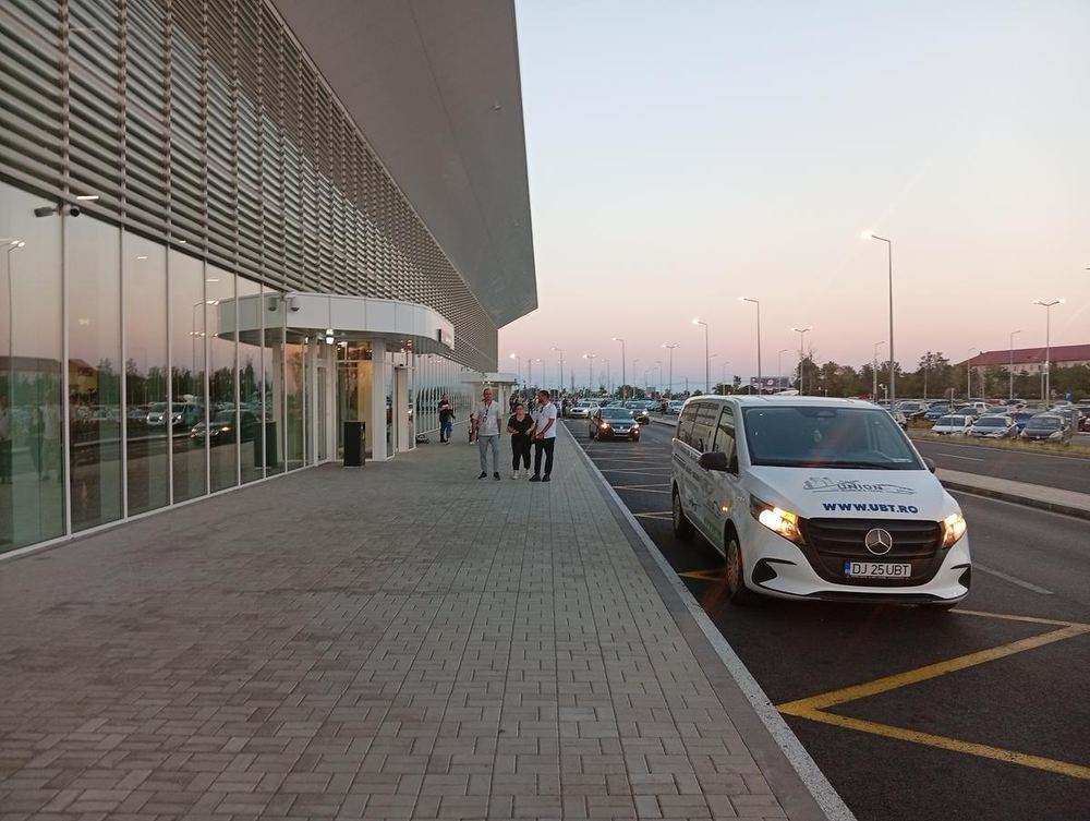 Kerbside — transfer vans wait a few steps from the door