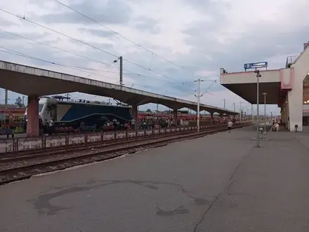 The platforms at Gara Craiova under the concrete canopies, CFR locomotive waiting, CRAIOVA sign on the station block