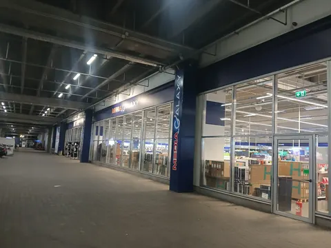 Media Galaxy entrance at Electroputere Mall, Craiova, lit up at night with the shop floor visible through the glass, September 2026