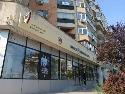 The Banca Transilvania branch on Calea București in Craiova — yellow fascia across the ground floor of the block