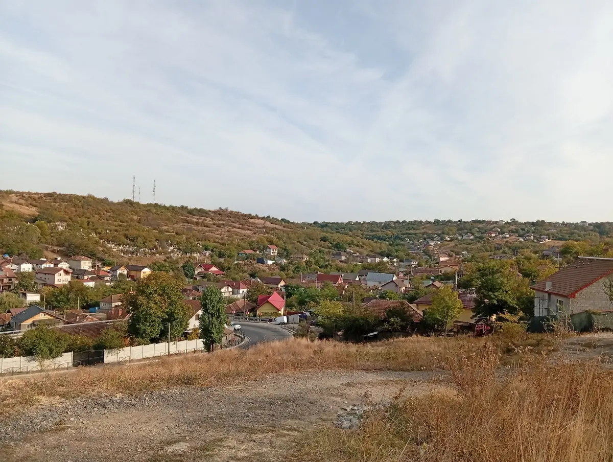 Ten minutes further down: Bucovăț village in its valley, with the cemetery on the slope and the masts on the ridge