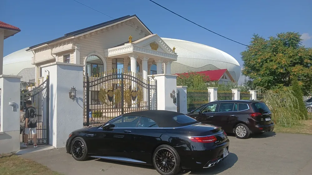 Gilded eagles on the gates of another on the same street, the stadium shell rising directly behind the roof
