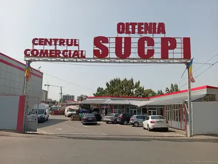 The red CENTRUL COMERCIAL OLTENIA SUCPI gantry sign over the entrance to the trading centre in Craiova