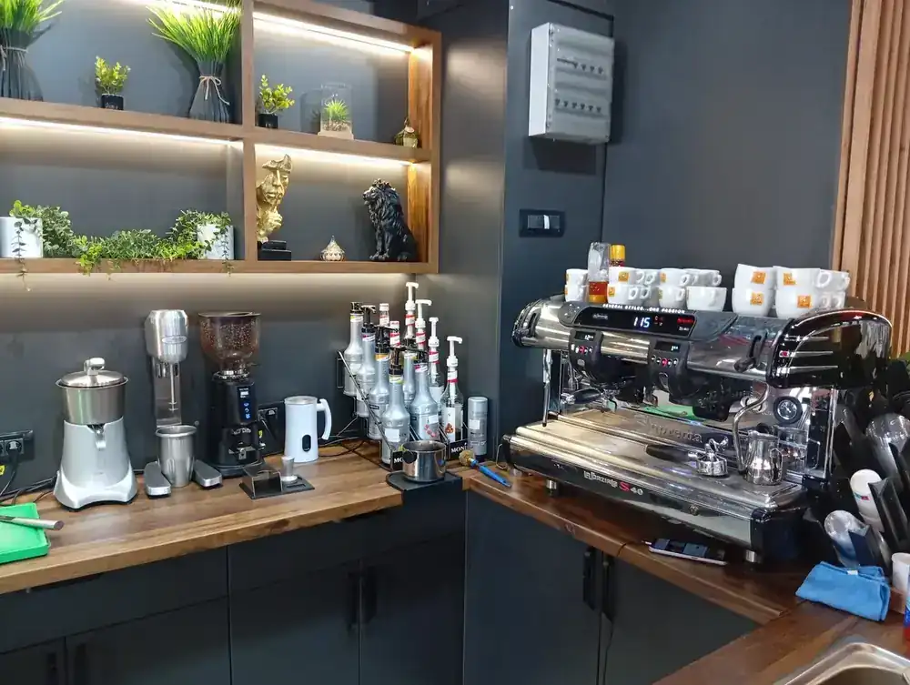 The barista station — grinder, syrups, shaker