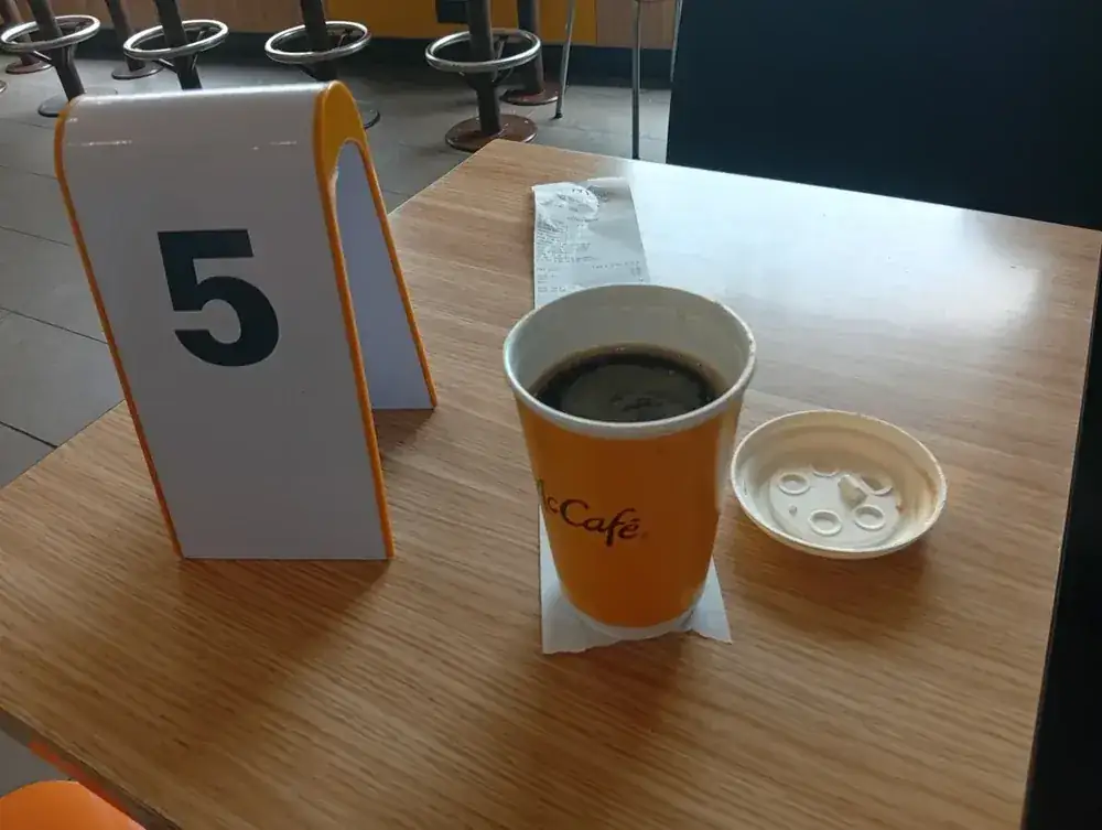 A grande at the table, brought over on your number