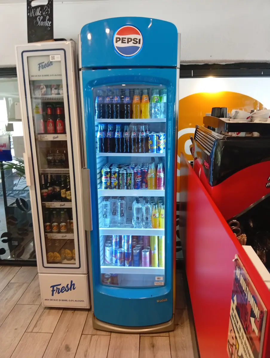 The drinks fridges and the coffee machine by the counter